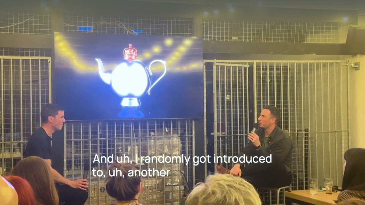 Chris Drury on stage at the Macc.xyz meetup, in conversation beside a screen