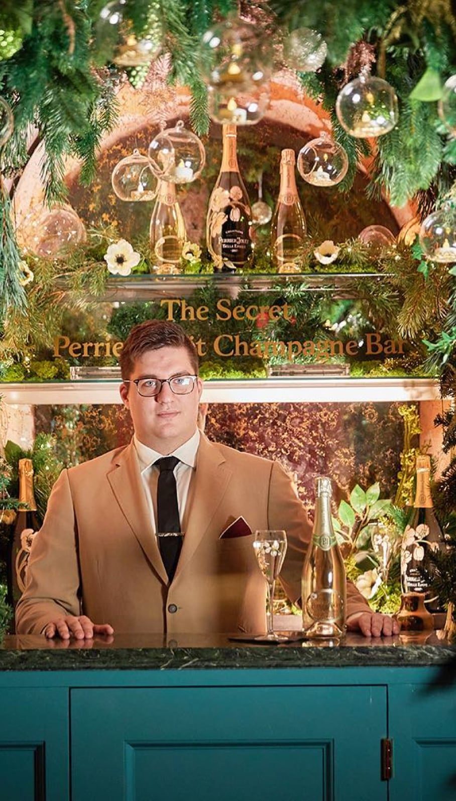 Club host in a tan suit among the floral interiors